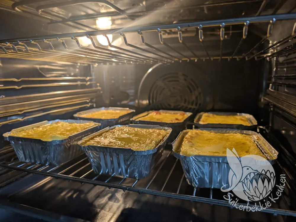 Zes bobotie in aluminium schaaltjes, goudbruin uit de oven
