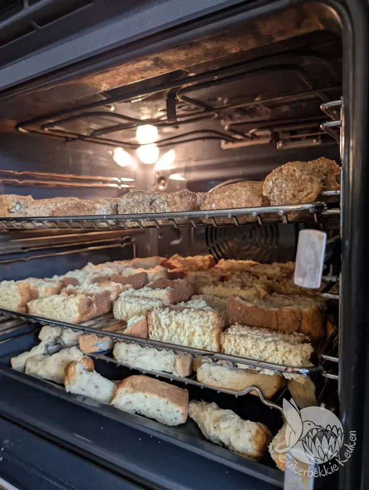 In stukken gesneden beskuit droogt op drie ovenroosters