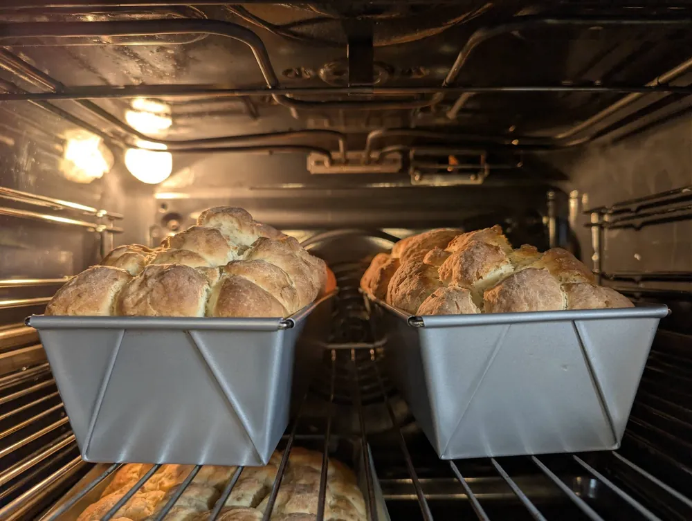 Golden baked mosbolletjie loaves, still whole in the pan