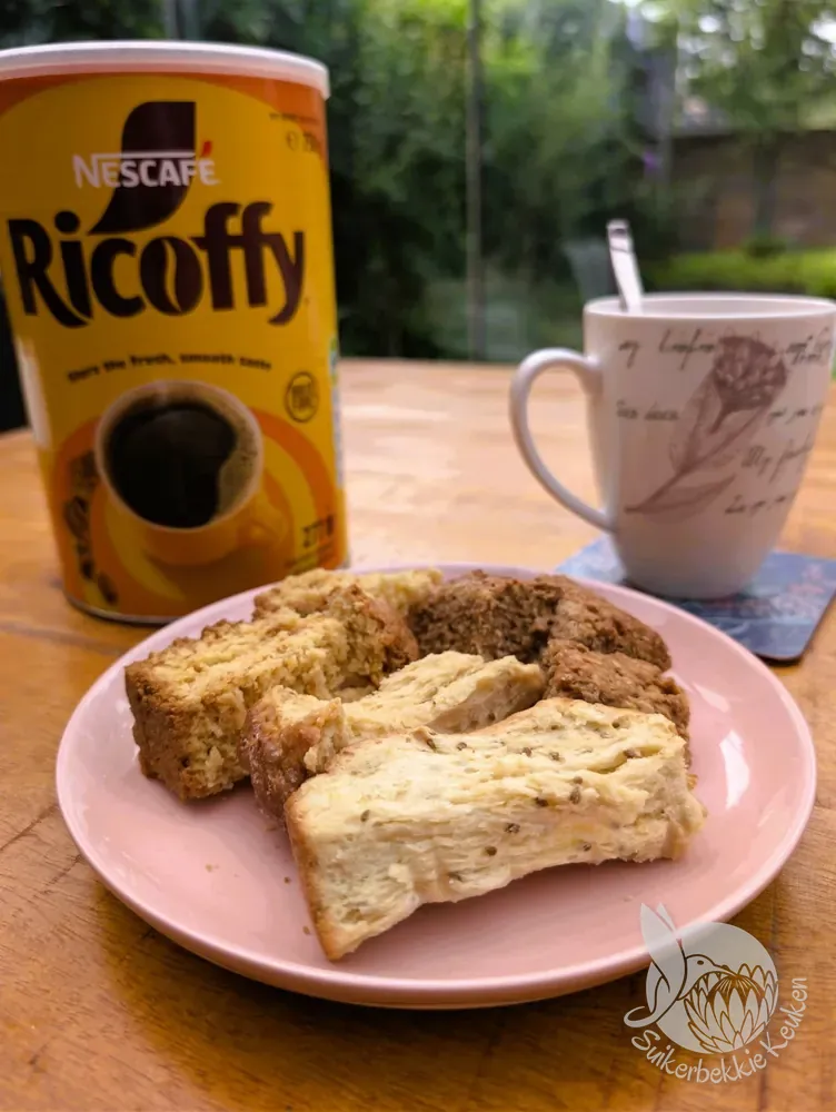 Blik koffie, bord met gemengde beskuit en een mok